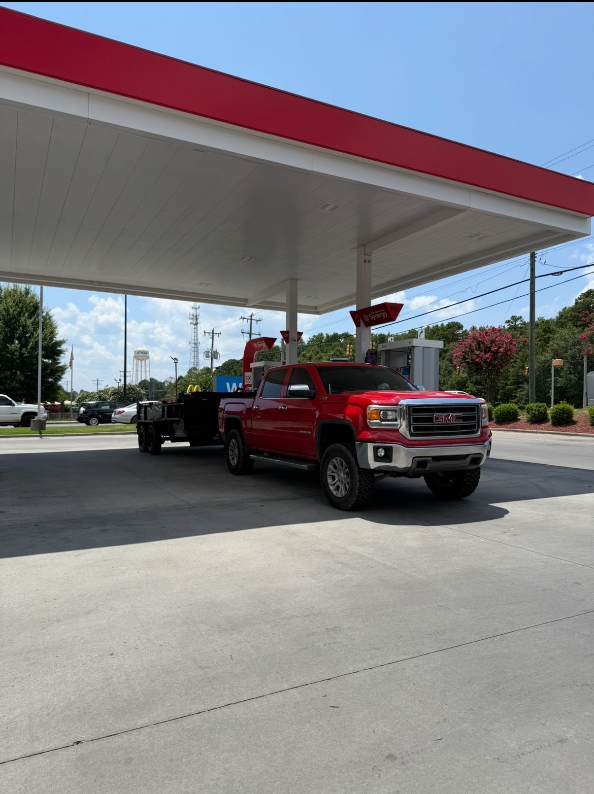 Red truck with loaded trailer at job site